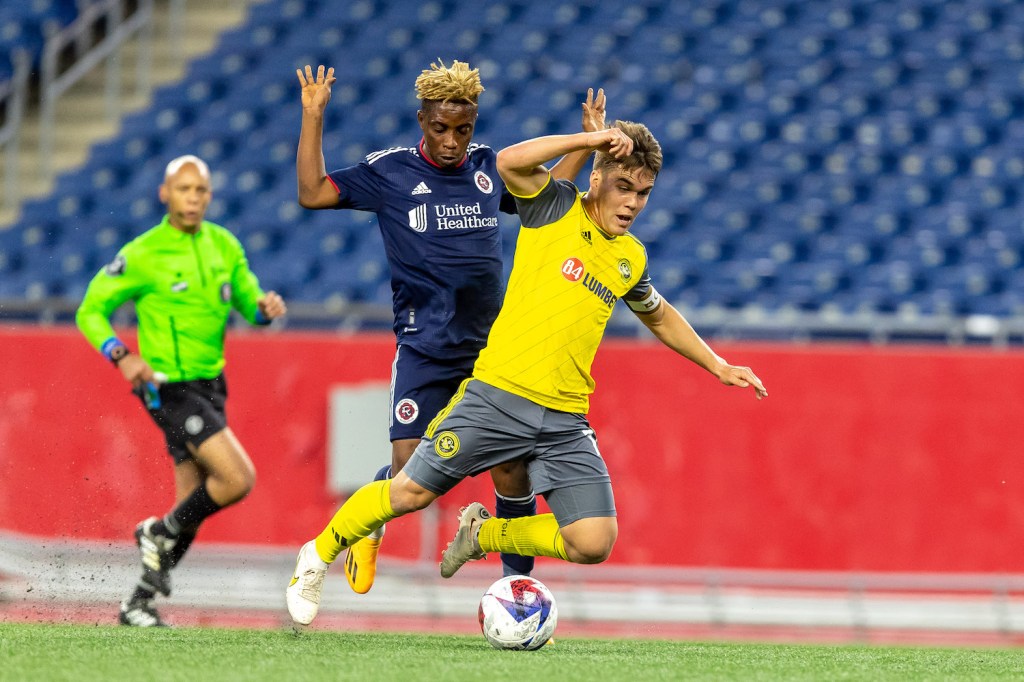 Riverhounds midfielder Robbie Mertz is fouled by the New England Revolution's Latif Blessing in the Hounds' 1-0 U.S. Open Cup win on May 9, 2023 at Gillette Stadium in Foxborough, Mass.