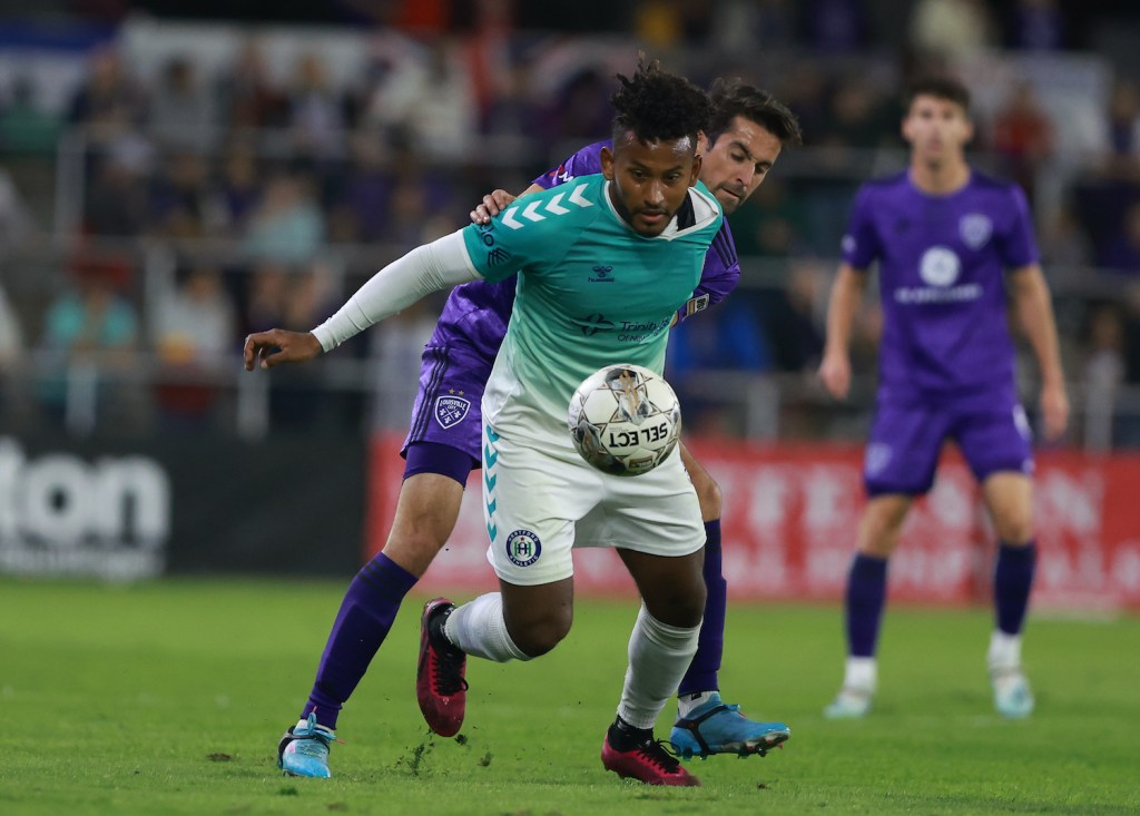 Juan Carlos Obregón Jr. holds off a Louisville defender while playing for Hartford Athletic in 2022