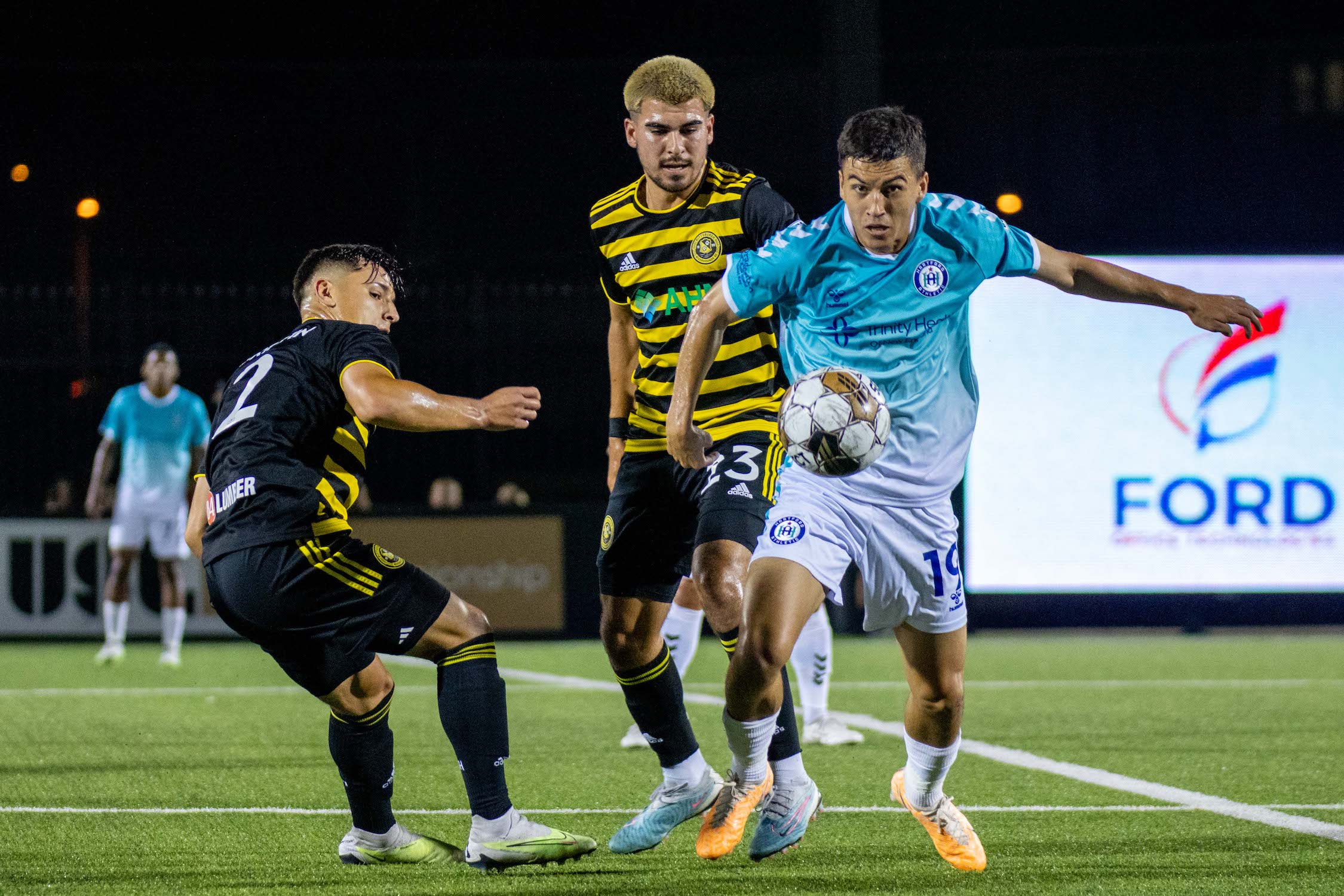 Riverhounds Marc Ybarra (center) and Danny Griffin challenge Hartford Athletic's Luke Merrill for the ball during the Hounds' 2-0 win at Highmark Stadium on Aug. 12, 2023.