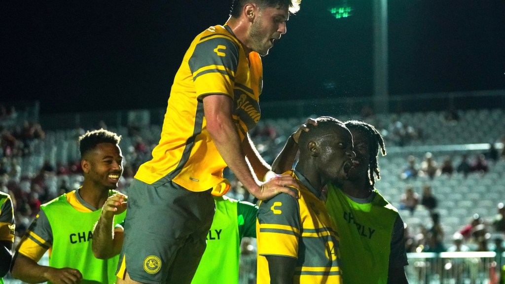 Teammates surround Edward Kizza after his goal in the Hounds' 3-1 win over Phoenix Rising FC in Phoenix on April 20, 2024.