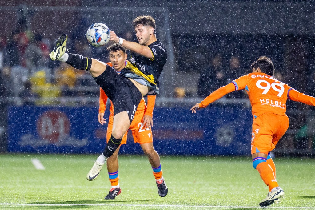 Picture of Riverhounds player challenging a ball in the air with two Miami FC players around him as the Hounds win their third straight- Pittsburgh Riverhounds SC