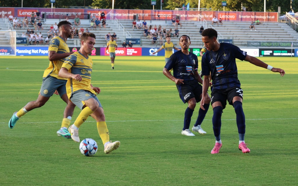 Pittsburgh Riverhounds player, Robbie Mertz, pulls back the ball in a game against North Carolina FC