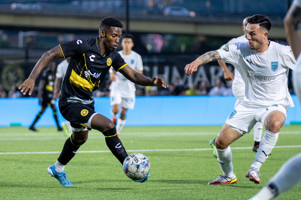 Pittsburgh Riverhounds Enoch Mushagalusa dribbles toward goal in against a defender from Monterey Bay FC at Highmark Stadium.