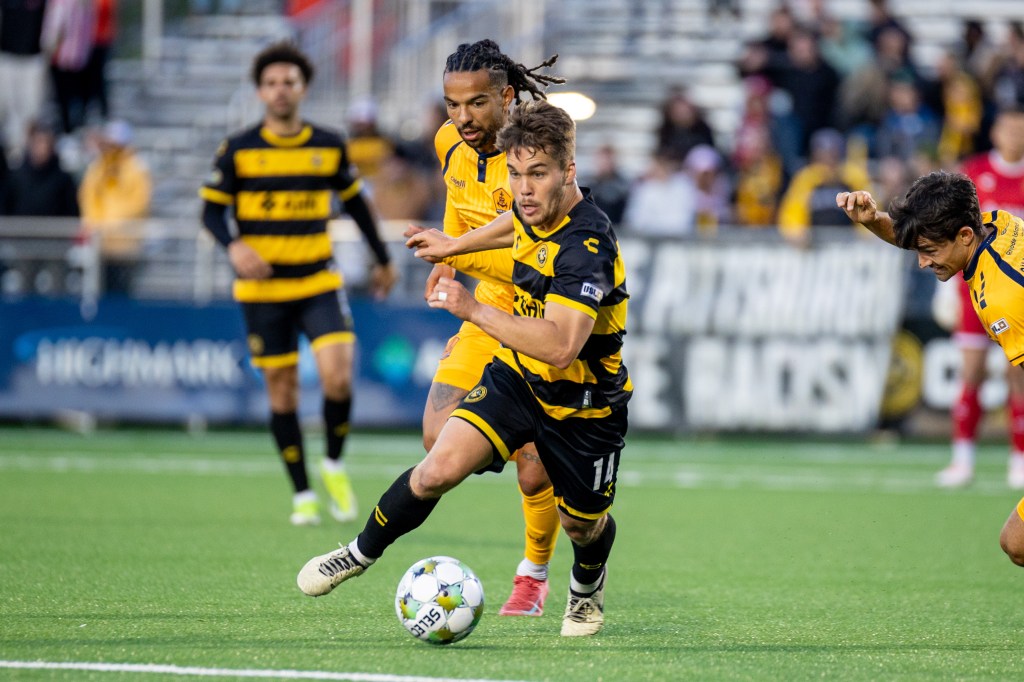 Pittsburgh Riverhounds midfielder Robbie Mertz evades Rhode Island FC's Noah Fuson in the team's USL Jägermeister Cup match May 31, 2025 at Highmark Stadium in Pittsburgh. (Photo: Chris Cowger/Riverhounds SC)