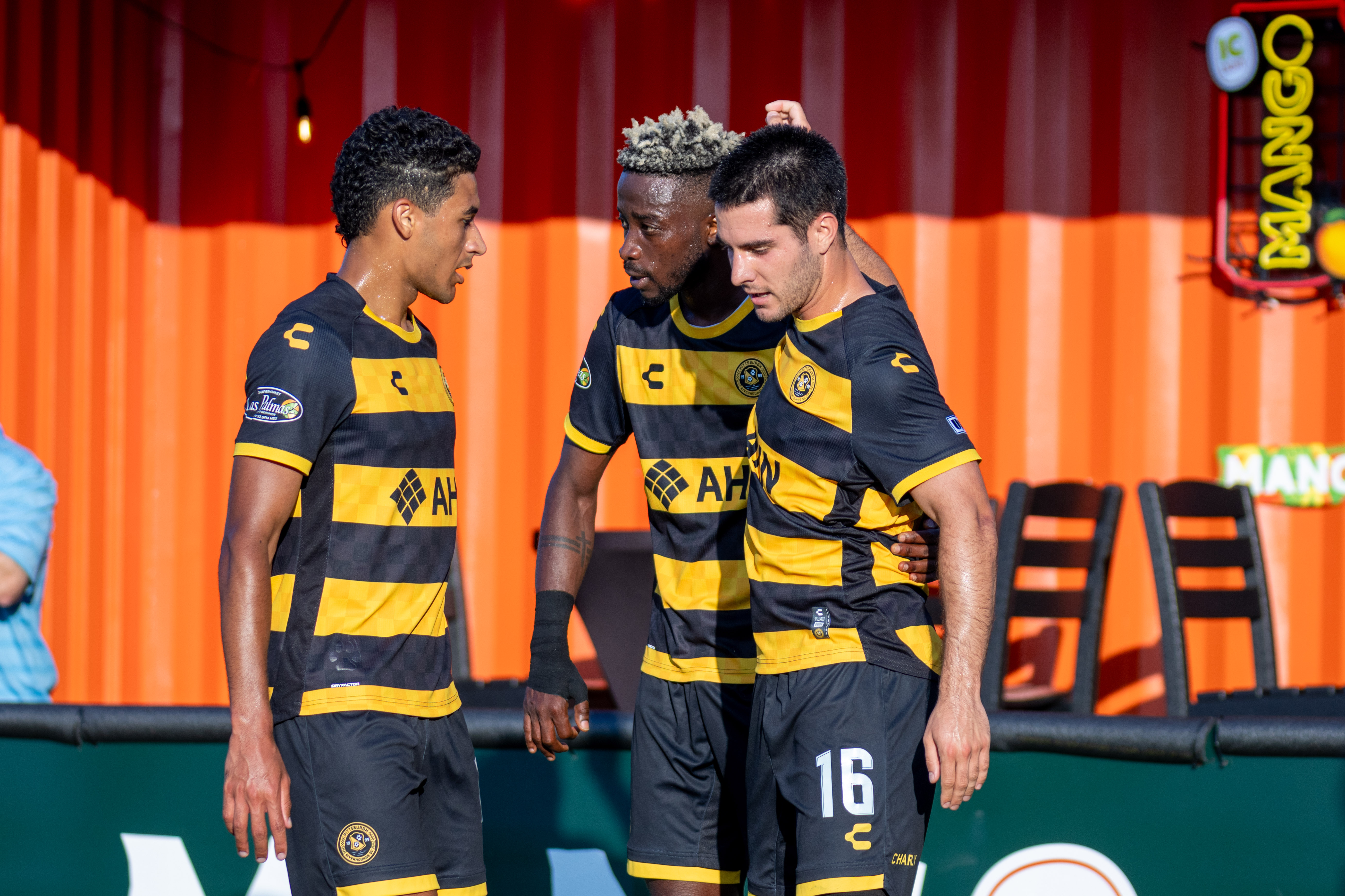 Augi Williams (center) is flanked by teammates Bertin Jacquesson and Beto Ydrach celebrating Williams' goal in the Pittsburgh Riverhounds' 2-1 win over the Tampa Bay Rowdies on June 21, 2025 at Highmark Stadium in Pittsburgh. (Photo: Chris Cowger/Riverhounds SC)
