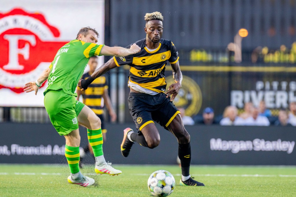 Pittsburgh Riverhounds forward Augi Williams dribbles past the Tampa Bay Rowdies' Lewis Hilton in the Hounds' 2-1 win on June 21, 2025 at Highmark Stadium in Pittsburgh. (Photo: Chris Cowger/Riverhounds SC)