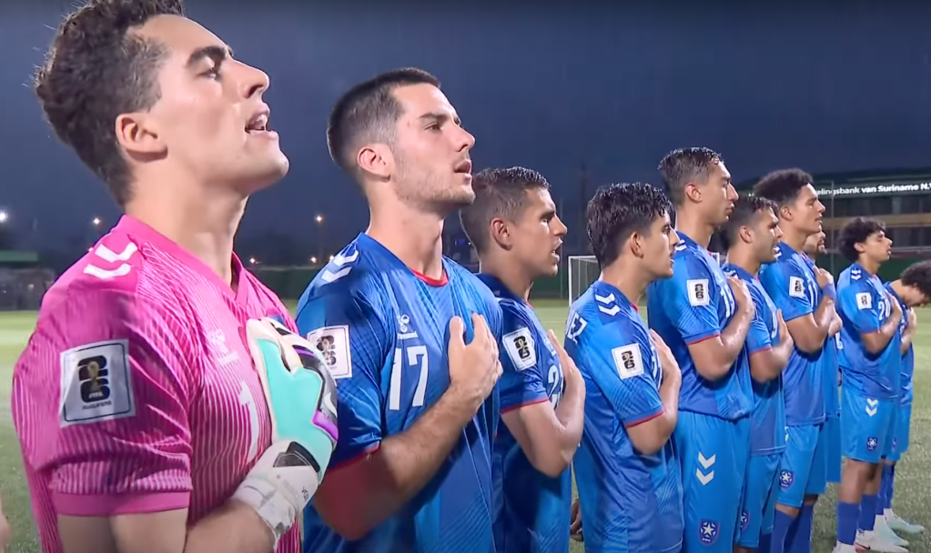 Beto Ydrach (17) stands with his teammates on Puerto Rico National Team during the playing of the national anthem before their FIFA World Cup qualifying match against Suriname on June 6, 2025 in Paramaribo, Suriname. (Screen shot courtesy of CONCACAF)