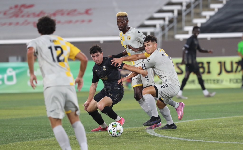 The Pittsburgh Riverhounds' Danny Griffin battles Birmingham Legion FC's Sebastian Tregarthen as teammate Augi Williams closes in during the teams' 1-1 draw Aug. 23, 2025 at Protective Stadium in Birmingham, Ala. (Photo courtesy of Birmingham Legion FC)