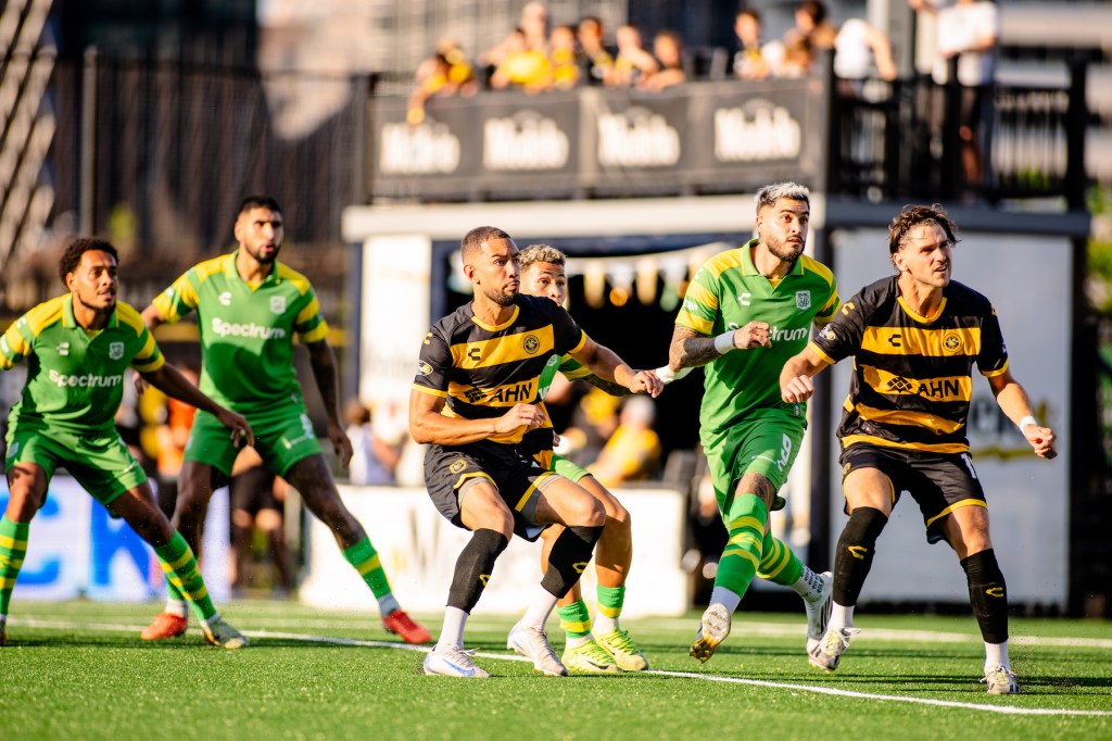 Guillaume Vacter (center) and Luke Biasi of the Pittsburgh Riverhounds move to win a corner kick among Tampa Bay Rowdies defenders in the Hounds' 2-1 win on June 21, 2025 at Highmark Stadium in Pittsburgh. (Photo: Ryan Shaffer/Riverhounds SC)