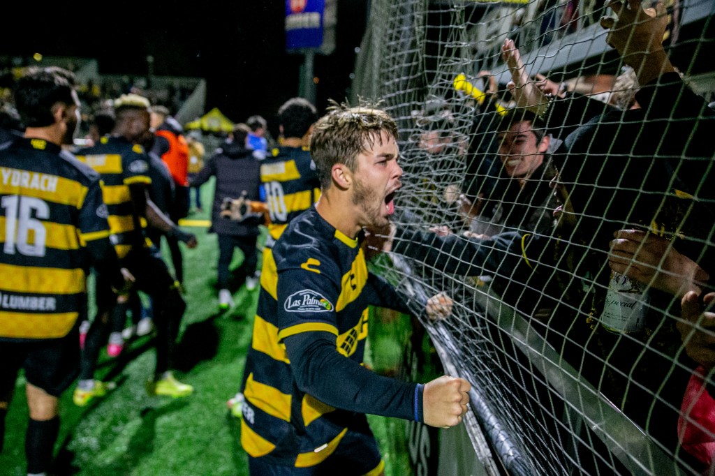 Robbie Mertz celebrates in front of the fans after the Pittsburgh Riverhounds advanced past Hartford Athletic, 4-2 on penalty kicks, in the USL Championship Playoffs on Nov. 1, 2025 at Highmark Stadium in Pittsburgh. (Photo: Chris Cowger/Riverhounds SC)