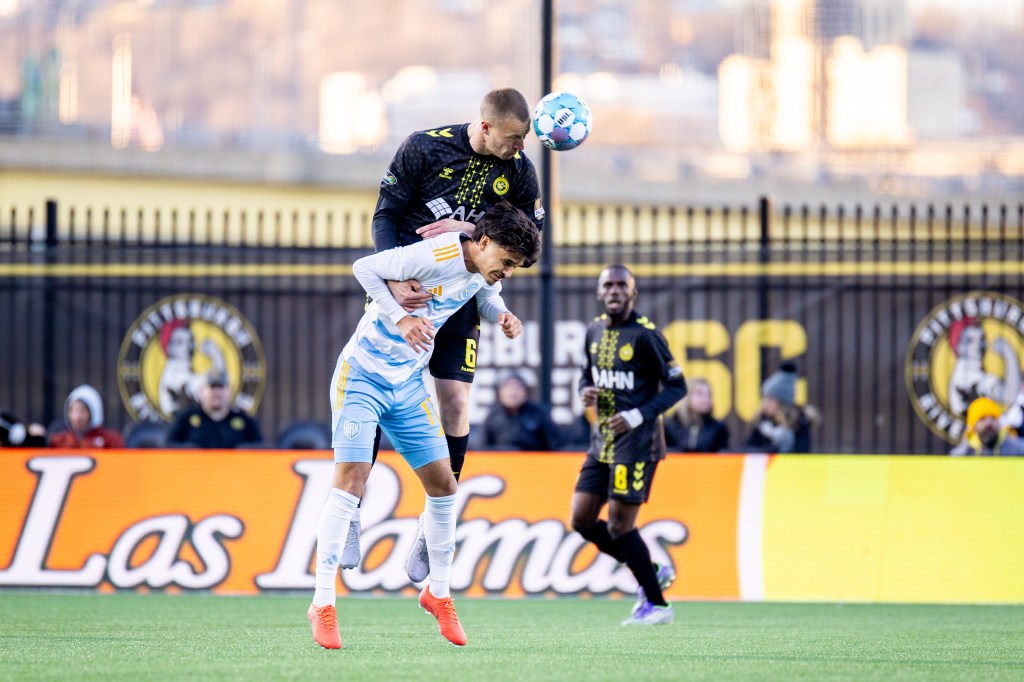 Owen Mikoy wins a header over Sporting Jacksonville's Zeke Soto in the Hounds' 3-2 triumph on March 28, 2026 at Highmark Stadium in Pittsburgh. (Photo: Chris Cowger/Riverhounds SC)