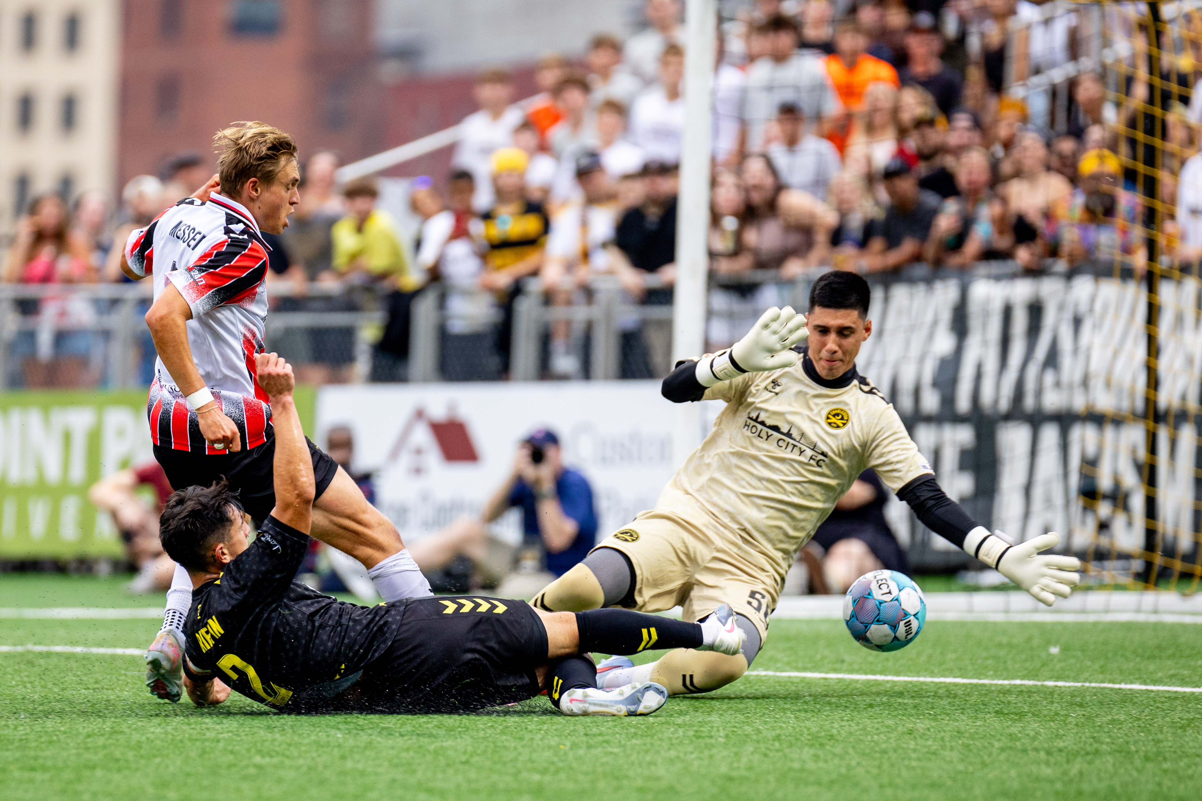 Danny Griffin slides the ball under the arm of Charleston Battery goalkeeper Luis Zamudio in the Pittsburgh Riverhounds' 3-1 win on Aug. 15, 2026 at F.N.B. Stadium in Pittsburgh. (Photo: Chris Cowger/Riverhounds SC)