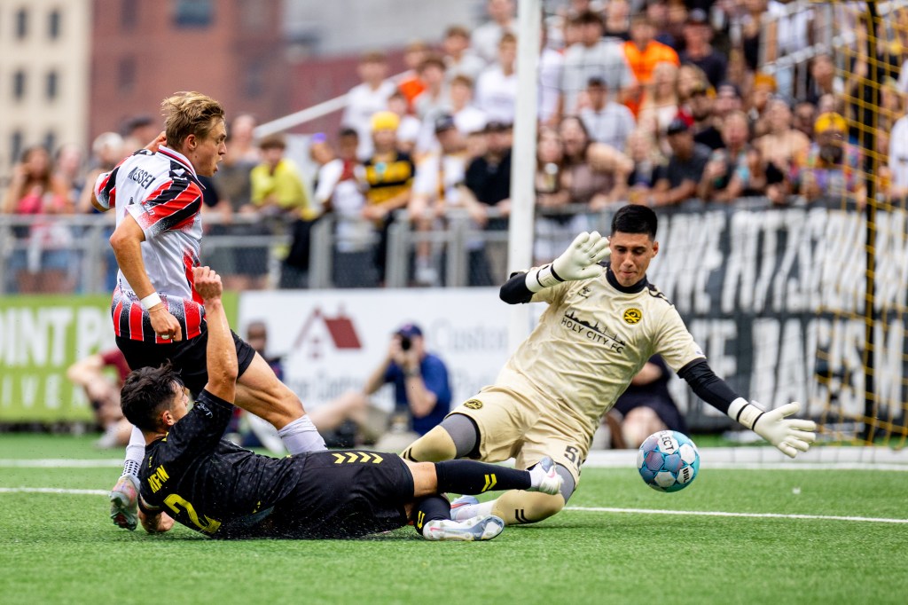 Danny Griffin slides the ball under the arm of Charleston Battery goalkeeper Luis Zamudio in the Pittsburgh Riverhounds' 3-1 win on Aug. 15, 2026 at F.N.B. Stadium in Pittsburgh. (Photo: Chris Cowger/Riverhounds SC)