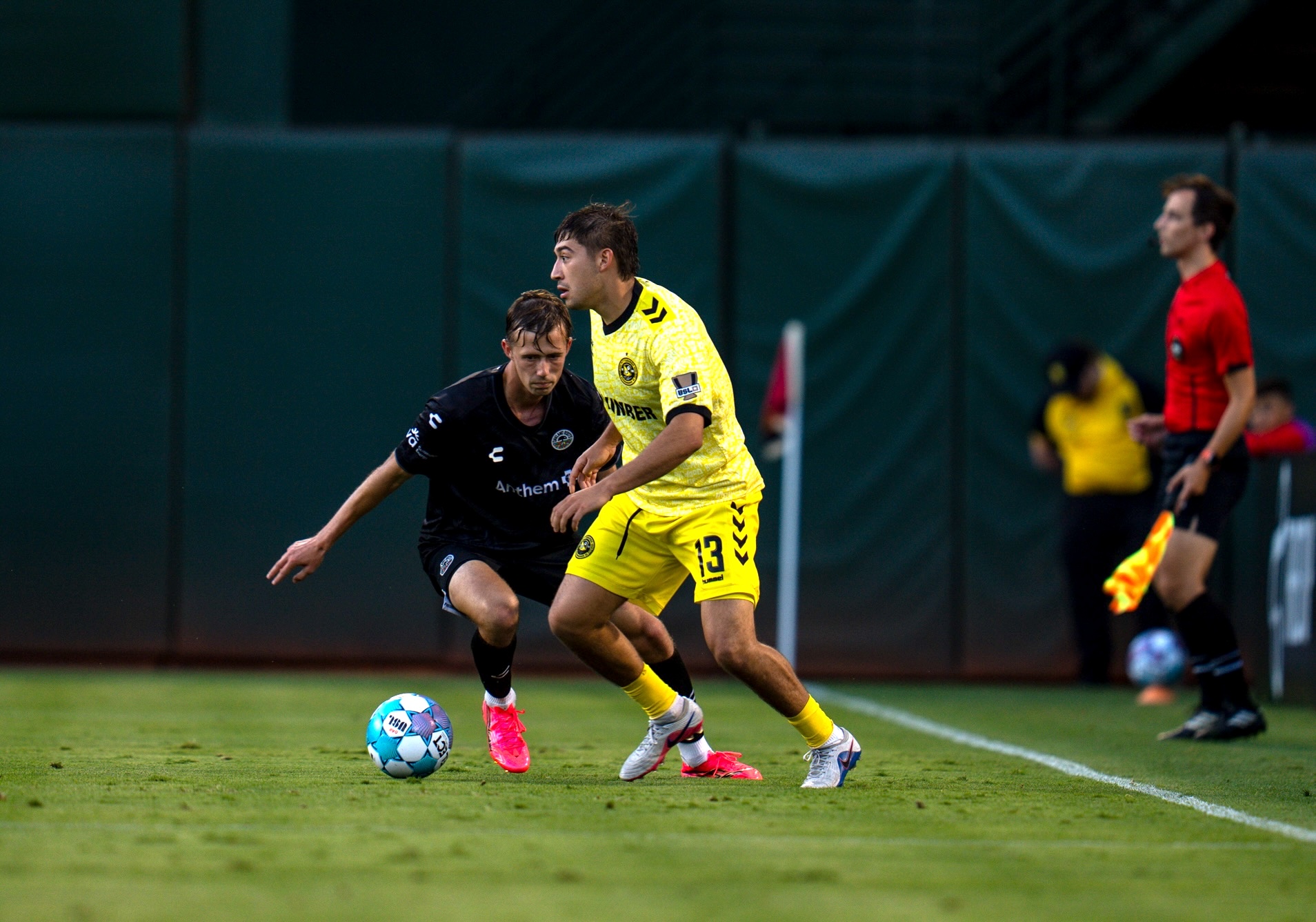 Max Viera looks for a teammate while being defended by Wolfgang Prentice of Oakland Roots SC in the Pittsburgh Riverhounds' 1-0 win on Aug. 1, 2026 at the Oakland Coliseum in Oakland, Calif. (Photo: Oakland Roots SC)