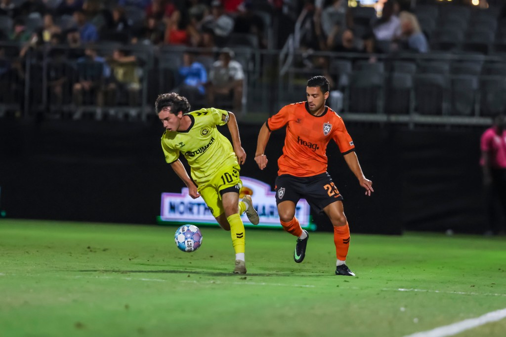 Charles Ahl dribbles away from Orange County SC defender Ryan Doghman in the Pittsburgh Riverhounds' match on Sept. 26, 2026 at Championship Soccer Stadium in Irvine, Calif. (Photo: Orange County SC)