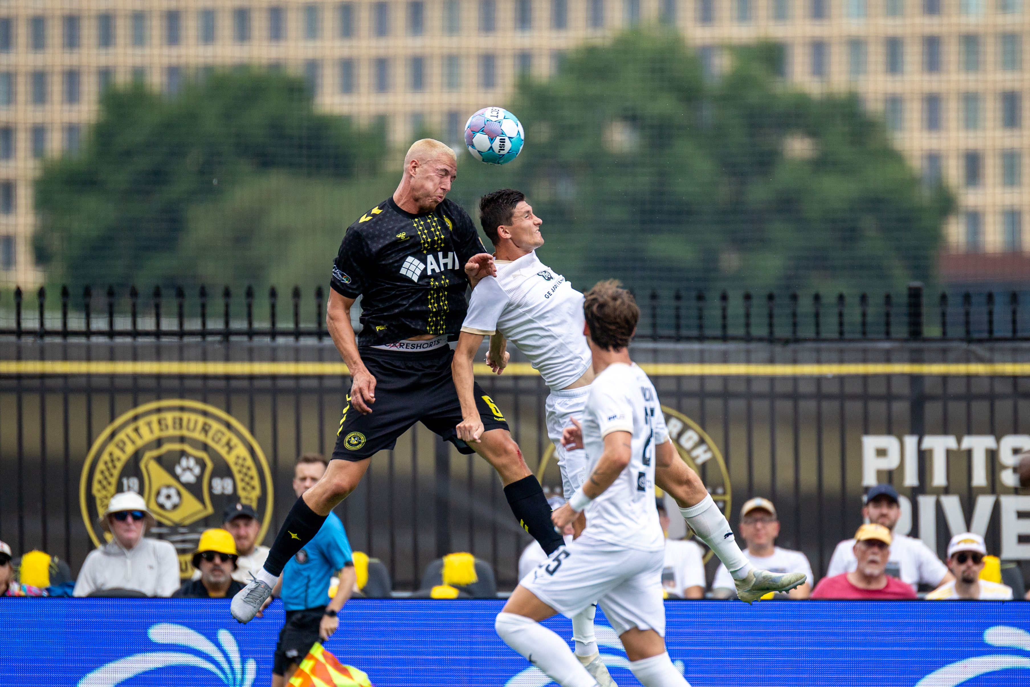 Owen Mikoy wins a header over Louisville City FC's Chris Donovan in the Pittsburgh Riverhounds' 3-1 win on July 18, 2026 at F.N.B. Stadium in Pittsburgh. (Photo: Chris Cowger/Riverhounds SC)