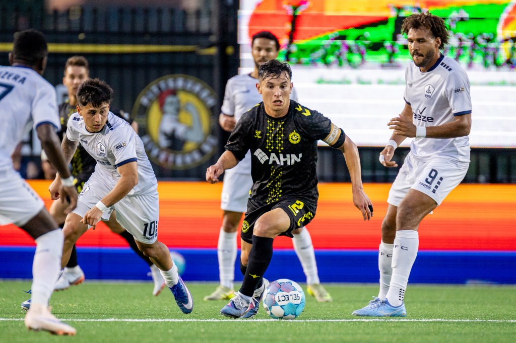 Danny Griffin dribbles between Rhode Island FC defenders in the Pittsburgh Riverhounds' match July 25, 2026 at F.N.B. Stadium in Pittsburgh. (Photo: Chris Cowger/Riverhounds SC)
