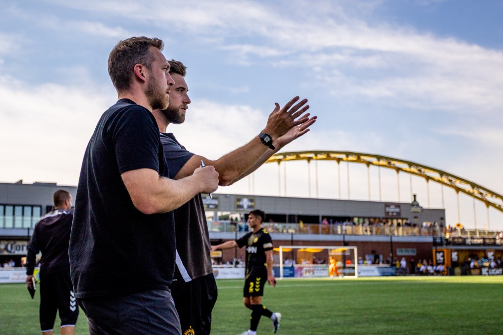 Pittsburgh Riverhounds coach Adam Mitchell (right) speaks with head coach Rob Vincent during the team's match against the Tampa Bay Rowdies on Aug. 29, 2026 at F.N.B. Stadium in Pittsburgh. (Photo: Chris Cowger/Riverhounds SC)